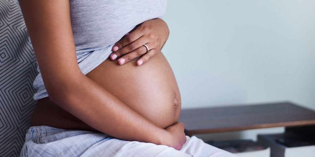 image of dark-skinned pregnant woman rubbing her belly
